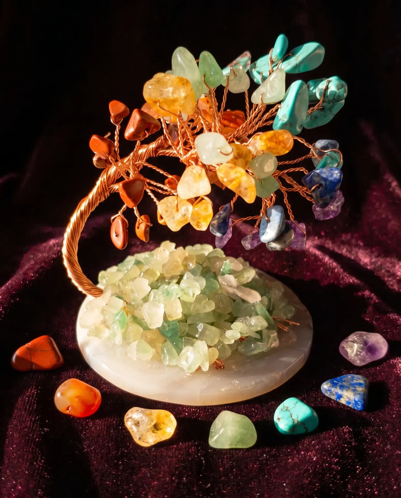 Seven Chakra Crystal Tree on dark velvet with chakra stones scattered around
